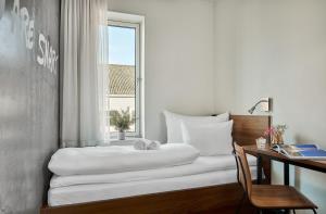a bedroom with a bed and a desk and a window at Smarthotel Tromsø in Tromsø +20 photos