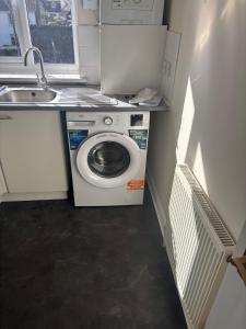 a washing machine in a small kitchen with a sink at Your choice apartment in Shirehampton