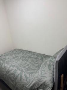 a bed with a green and white blanket on it at Your choice apartment in Shirehampton