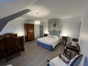 a bedroom with a bed and a table and chairs at Domaine du moulin de la plaine in Trôo +46 photos