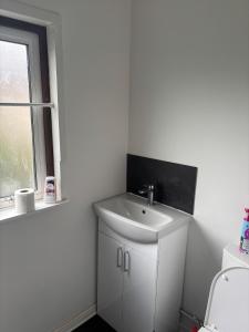 a white bathroom with a sink and a window at Your choice apartment in Shirehampton +4 photos