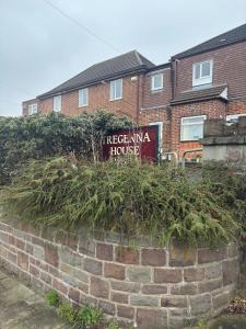 a brick wall with a sign in front of a house at Your choice apartment in Shirehampton