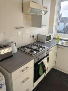 a kitchen with a stove and a microwave at Your choice apartment in Shirehampton