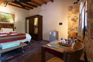a bedroom with a bed and a table in a room at Araoz de Lamadrid Wine Lodge in San Javier +101 photos