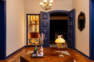 a room with a table with a lamp and a blue door at Altos de Colombo Guest House Boutique - Soft Opening in Rio de Janeiro