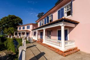 a pink house with a porch and a balcony at Altos de Colombo Guest House Boutique - Soft Opening in Rio de Janeiro