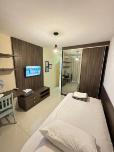 a bedroom with a bed and a tv and a mirror at PRAIA DO FORTE ALTO LUXO in CFB +61 photos