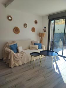 a living room with a couch and two tables at Casa ELYVMY in Zonza