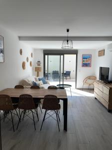 a living room with a table and chairs and a couch at Casa ELYVMY in Zonza
