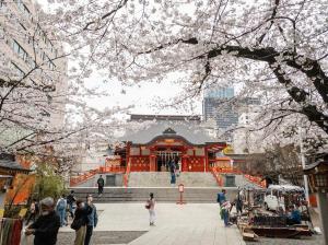 a temple in a city with people walking around it at HARERUYA Inn SHINJUKU in Tokyo