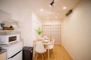 a small kitchen with a table and a microwave at HARERUYA Inn SHINJUKU in Tokyo