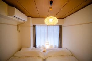 two beds in a room with a window at HARERUYA Inn SHINJUKU in Tokyo +51 photos