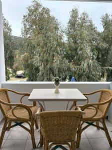 a white table and chairs on a balcony with a view of trees at Το Αίθριο in Galissas
