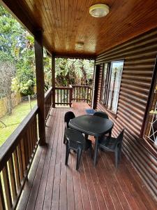 a wooden porch with a table and chairs on it at Die Anker Kothuis in Southbroom