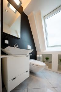 ein Badezimmer mit Toilette, Waschbecken und Fenster in der Unterkunft View Pilatus-Luxus-Maisonette mit Pilatusblick - 6 Personen - PP in Luzern + 72 Fotos