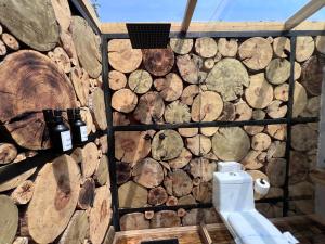 a bathroom with a logs wall with a toilet at Cabañas El Principio y Spa en Huasca de Ocampo in Huasca de Ocampo +85 photos