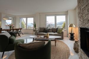 ein Wohnzimmer mit Sofa und Kamin in der Unterkunft View Pilatus-Luxus-Maisonette mit Pilatusblick - 6 Personen - PP in Luzern