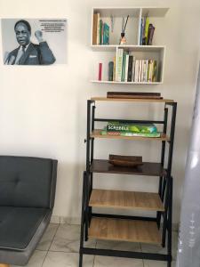 a shelf in a room with a couch and books at Studio 1 chambre in Port-Gentil