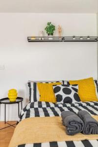 a bedroom with a black and white bed with yellow pillows at Spacious 4-Bed Home with Workspace in Coundon