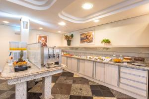 a kitchen with a counter with food on it at Hotel Metropolitan Canoas in Canoas