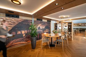 a restaurant with a table and chairs and a painting at Restaurant & Hotel Frohsinn in Küssnacht