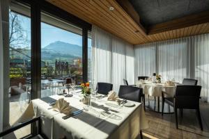 a restaurant with white tables and chairs and a large window at Restaurant & Hotel Frohsinn in Küssnacht