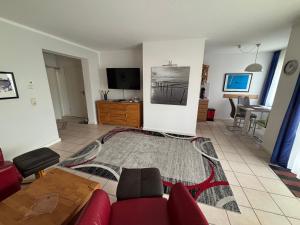 a living room with a red couch and a tv at Ferienwohnung Andresen in Rerik