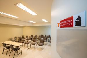 a conference room with tables and chairs and a sign at Hotel Metropolitan Canoas in Canoas