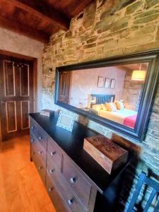 a bedroom with a large mirror on a stone wall at Lar das louseiras in Rozabragada +13 photos