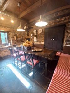 a dining room with a large wooden table and chairs at Lar das louseiras in Rozabragada