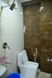 a small bathroom with a toilet and a sink at VRJInn in Vellore +15 photos