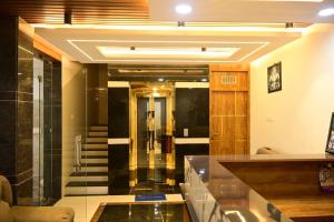 a lobby with a hallway with a person walking up the stairs at VRJInn in Vellore