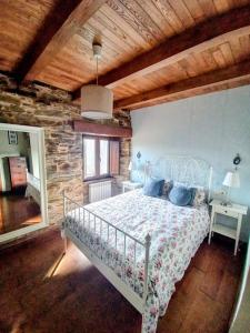 a bedroom with a bed and a wooden ceiling at Lar das louseiras in Rozabragada
