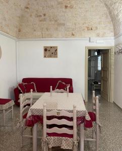 a living room with a table and a red couch at Casa Renza in Locorotondo