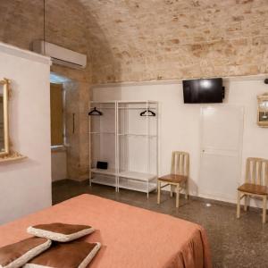a room with a bed and two chairs and a table at Casa Renza in Locorotondo