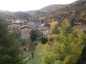 a village in the mountains with trees and buildings at Hostal El Forn in Beget
