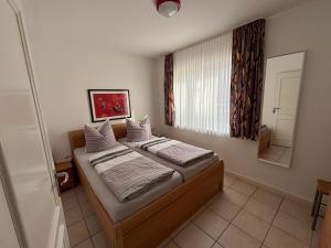 a small bedroom with a bed and a mirror at Ferienwohnung Andresen in Rerik