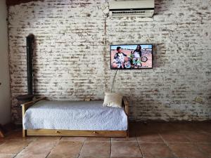 a bedroom with a bed and a brick wall at Casa Quinta Malu in Gualeguaychú +3 photos