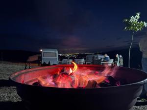 a fire pit with a fire burns in it at night at La Nuci in Valea scheilor