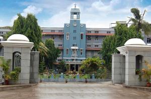 a large blue building with a clock tower at VRJInn in Vellore