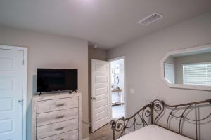 a bedroom with a bed and a tv on a dresser at Off the Grid in Foley +14 photos