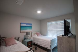 a bedroom with two beds and a flat screen tv at Off the Grid in Foley
