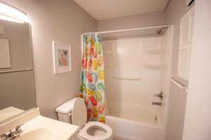 a bathroom with a toilet and a shower curtain at Salty Dune 2BR Beach Condo w Pools in Gulf Shores