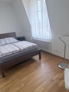 a bedroom with a bed and a wooden floor at Apartments Justingerweg Bern in Bern