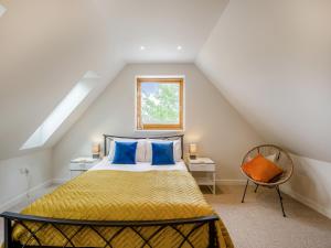 a bedroom with a bed with blue pillows and a window at Pond View Loft in Sudbury