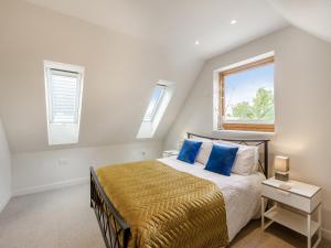 a bedroom with a bed with blue pillows and a window at Pond View Loft in Sudbury