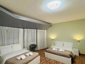 a bedroom with two beds with white towels on them at MMM HOME Train Station 1 in Mestre
