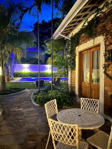 a table and chairs on a patio at night at Pousada Manacá Exclusive Suítes in Rifaina