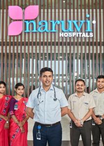 a group of people standing in front of a sign at VRJInn in Vellore