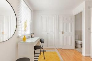 a bathroom with a mirror and a desk and a toilet at Spacious 4-Bed Home with Workspace in Coundon +26 photos